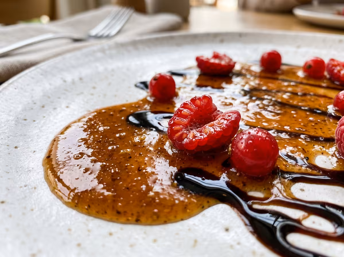 Gros plan sur une sauce riche et brillante pour magret de canard, avec réduction balsamique.